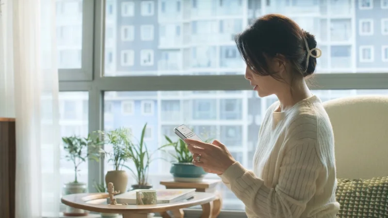 Người xem điện thoại trong căn hộ, minh họa theo dõi khoản vay
