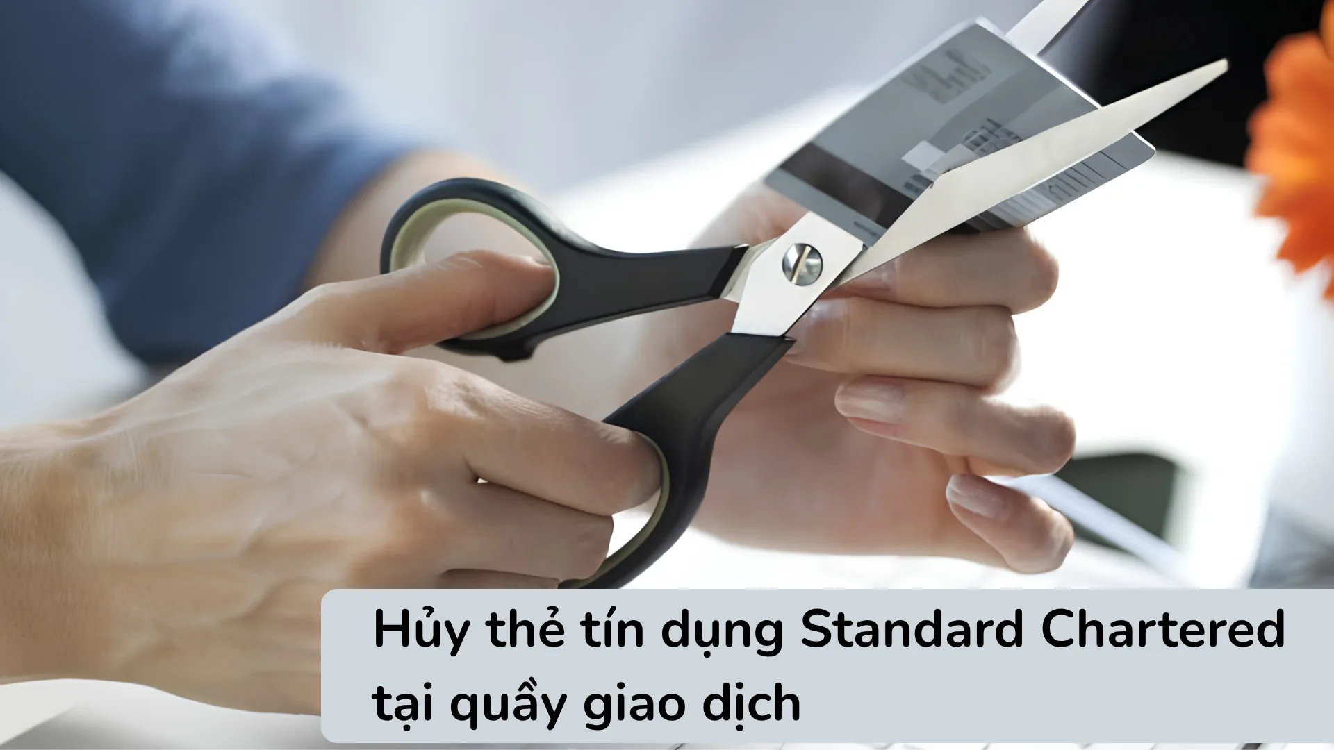 Nhân viên Standard Chartered tiến hành cắt hủy thẻ nhựa vật lý trực tiếp tại quầy giao dịch để đảm bảo an toàn thông tin.