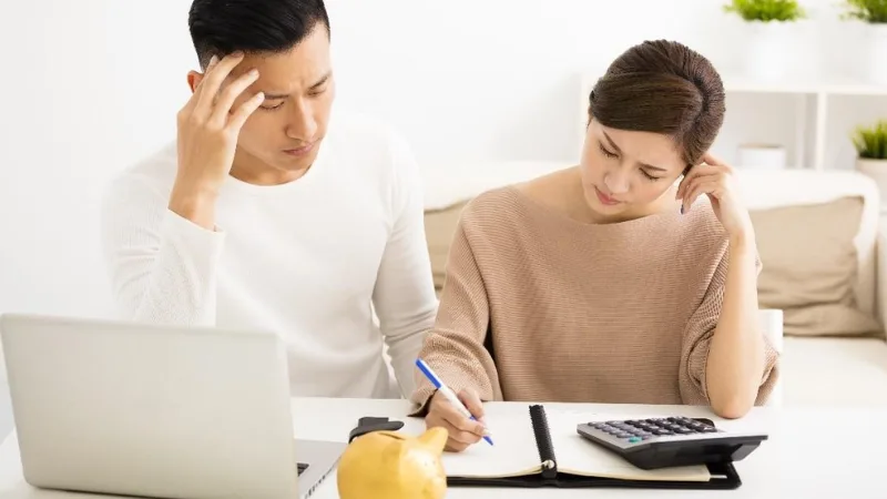 Cặp vợ chồng tính toán chi phí bằng máy tính
