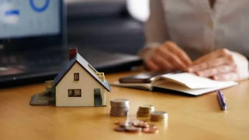 Người tính toán khoản vay bên mô hình ngôi nhà và đồng xu